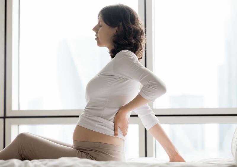Đau lưng dưới khi mang thai thường là các cơn đau âm ỉ, nhận thấy rõ nhất khi đứng hoặc ngồi lâu
